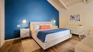 a blue bedroom with a bed and a blue wall at Racquet Club Retreat Modern Luxe Living in a Peaceful Desert Escape – managed by Greenday in Rancho Mirage