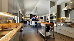 a large kitchen with a counter and a dining room at “Luxe Living”: Modern elegance, top-tier amenities, and stunning views, managed by Greenday! in Rancho Mirage