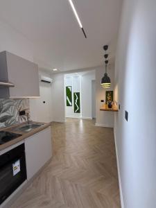 a kitchen with white cabinets and a wooden floor at Ulivo Guest House Roma in Rome