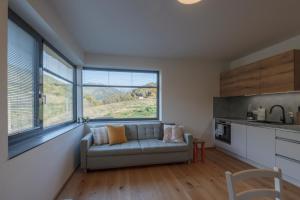 a living room with a couch and some windows at Elements Chopok in Bystrá