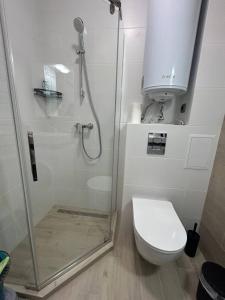 a white bathroom with a shower and a toilet at Apartment Polyana Green Park in Polyana +27 photos