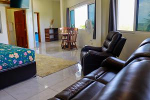 a living room with a leather couch and chairs at Harbour Place Suites in Placencia Village