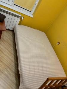 un matelas dans un coin d'une pièce avec un mur jaune dans l'établissement Galina apartment, à Ruse