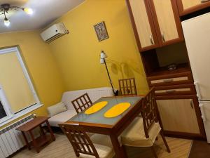 a dining room with a table and chairs and a couch at Galina apartment in Ruse