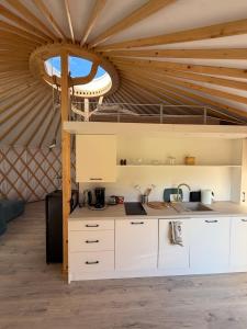 a kitchen with white cabinets in a yurt at Jurta Lake It Easy 
