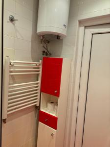 a bathroom with a red cabinet and a light at Galina apartment in Ruse +18 photos