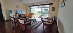 a living room with chairs and a table and a window at Seaview SS palm terrace serviced apt-nyali in Mombasa