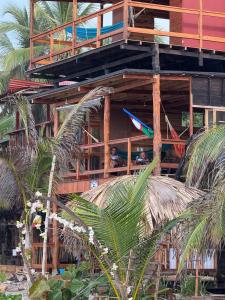 two people sitting on a balcony of a building at Casa Maya Mendihuaca in Playa Mendiguaca