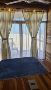 a bedroom with a bed and a large window at Casa Maya Mendihuaca in Playa Mendiguaca