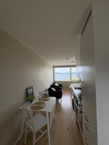 a living room with a table and a kitchen at Cozy Apartment in Tromsø