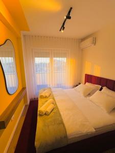 a bedroom with a large bed with yellow walls at Urban Apartments CityCenter in Gjakove