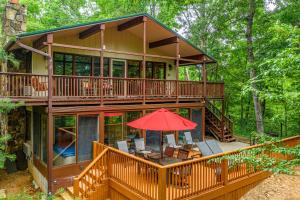 a large house in the woods with a red umbrella at Buena Vista Getaway by American Patriot Getaways in McCookville