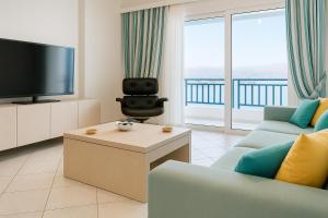 a living room with a tv and a couch and a table at Sea view in Karpathos