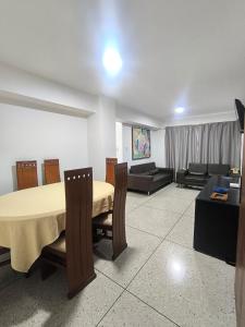 MéridaApartamento Av Las Americas 3 habitaciones的客厅里有一张桌子和一张沙发