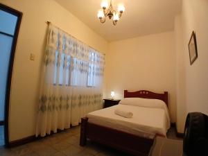 パルミラにあるApartamento Amplio y Cómodo en el centro de Palmiraのベッドとシャンデリアのある寝室