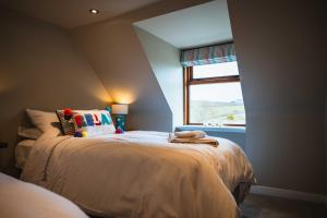 Un dormitorio con una cama grande con ventana. en Bramble Cottage, en Turriff