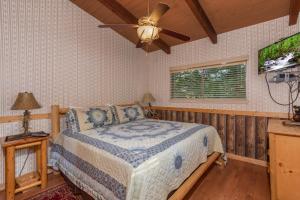 ein Schlafzimmer mit einem Bett und einem Deckenventilator in der Unterkunft Bushwood Lodge by American Patriot Getaways in Chalet Village + 29 Fotos