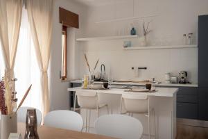 a kitchen with a white counter and white stools at LUXURY - Casa dell'artista in Grottammare
