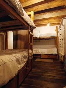 two bunk beds in a room with wooden ceilings at Amuya Hostel in Chiquinquirá +80 photos