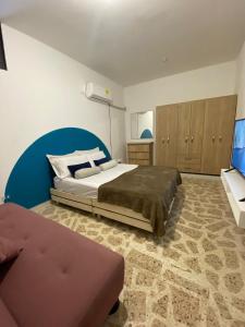 a bedroom with a large bed and a couch at Como en casa in Ríohacha