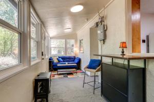 a living room with a blue couch and windows at Wine Country Cottage in Historic Fiddletown! in Fiddletown
