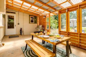 a kitchen with a table in a conservatory with windows at Wine Country Cottage in Historic Fiddletown! in Fiddletown