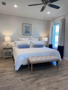 a bedroom with a large bed with a ceiling fan at Sunset Sanctuary in Dauphin Island