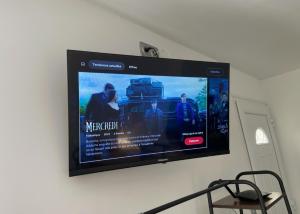 a flat screen tv hanging on a wall at Studio calme climatisé, Wi-Fi, arrivée autonome in Douai