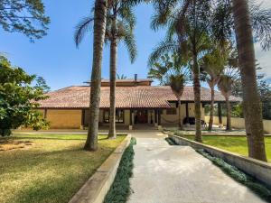a house with palm trees in front of it at Refúgio de Alto Padrão na Granja Viana in Carapicuíba