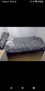 a bed in a room with a black and white comforter at Bas de villa à 100 M de la plage in Solaro