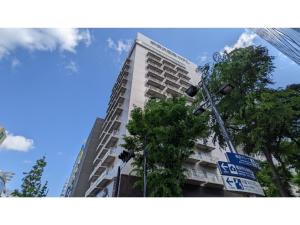 um edifício alto com uma placa de rua em frente em Shinyokohama Kokusai Hotel - Vacation STAY 62807v em Yokohama