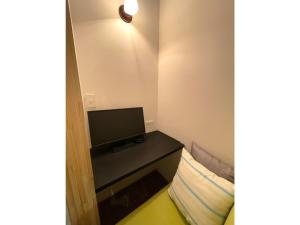 ein kleines Zimmer mit einem Fernseher und einem Tisch mit einem Kissen in der Unterkunft ＳＥＫＫＡ ＳＨＩＲＥＴＯＫＯ - Vacation STAY 66952v in Shimatokkari + 10 Fotos