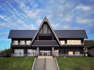 ein großes schwarzes Haus mit einem Walmdach in der Unterkunft ＳＥＫＫＡ ＳＨＩＲＥＴＯＫＯ - Vacation STAY 66952v in Shimatokkari