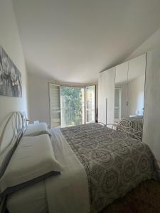 a white bedroom with a large bed and a window at B&B Le Peonie Alloggio centrale vicino al mare in Ravenna +9 photos