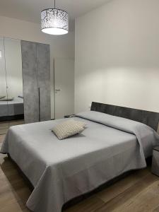 ジャルディーニ・ナクソスにあるAF Holiday Homesの白いベッドルーム(大型ベッド1台、シャンデリア付)