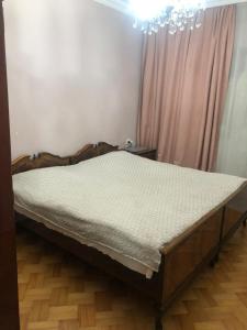 a bed in a bedroom with a chandelier at Parso Apartment in Batumi