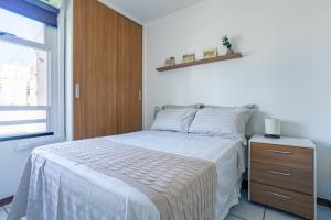 ブラジリアにあるAsa Norte com garagem e elevador 4 km da Esplanadaのベッドルーム1室(ベッド1台、木製キャビネット、窓付)