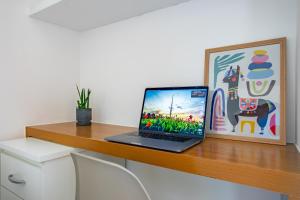 ブラジリアにあるAsa Norte com garagem e elevador 4 km da Esplanadaの木製の机の上に置かれたノートパソコン