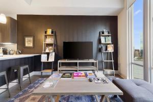 a living room with a table and a tv at The Stevie Ray Vaughan Flat ATX in Austin
