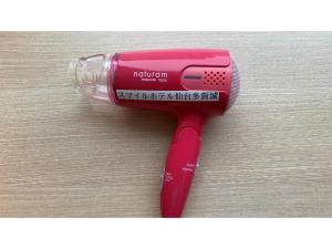un asciugacapelli rosso appoggiato su un tavolo di Smile Hotel Sendai Tagajyo - Vacation STAY 84220v a Tagajo
