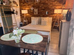 a room with two beds and a table with plates on it at Petit cocon cosy proche place Stanislas-Parking & cave vélos in Nancy