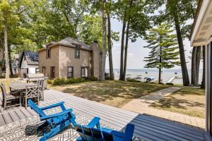 a deck with chairs and a table and a house at Swim, Fish and Boat House on Stunning Higgins Lake! in Higgins Lake