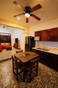 a kitchen with a table and a ceiling fan at Casa Tio Roger in Mérida +40 photos
