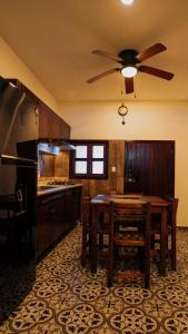 a kitchen with a table and a ceiling fan at Casa Tio Roger in Mérida