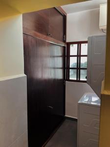 a kitchen with a black refrigerator in a room at Casa Tio Roger in Mérida