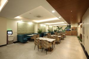 a restaurant with tables and chairs and a tv at Rukman Hotels in Jaipur