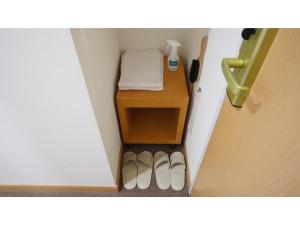 a small room with a bed and two shoes at Smile Hotel Shizuoka Yoshida Inter - Vacation STAY 90911v 