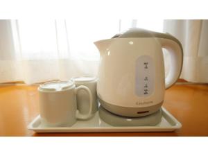 a tea kettle and two cups on a plate at Smile Hotel Shizuoka Yoshida Inter - Vacation STAY 90911v 