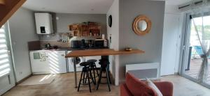 a kitchen with a counter with stools in it at La Péra in Putanges