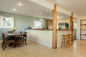 a kitchen and dining room with a table and chairs at Sunset Orchard- Sunny Side of Waimea, Close to Beaches! in Waimea